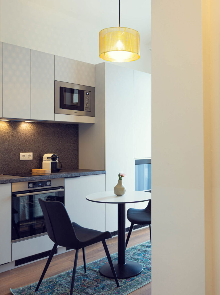 Blick in eine Küche mit kleinem Esstisch und zwei Stühlen