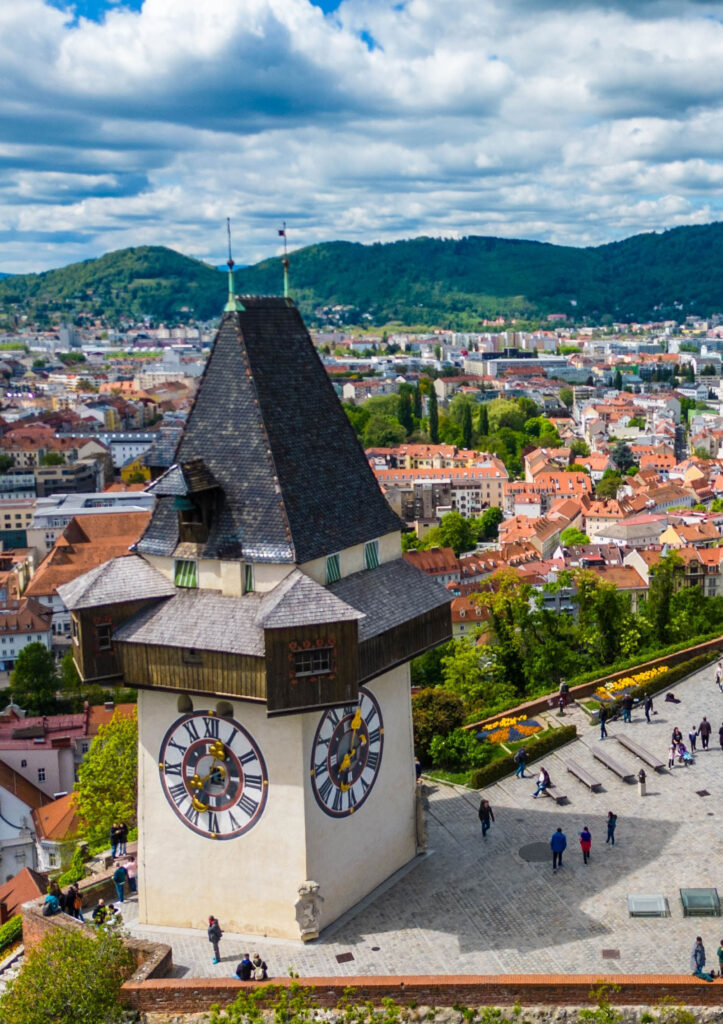 Blick auf den Grazer Uhrturm mit Panorama im Hintergrund